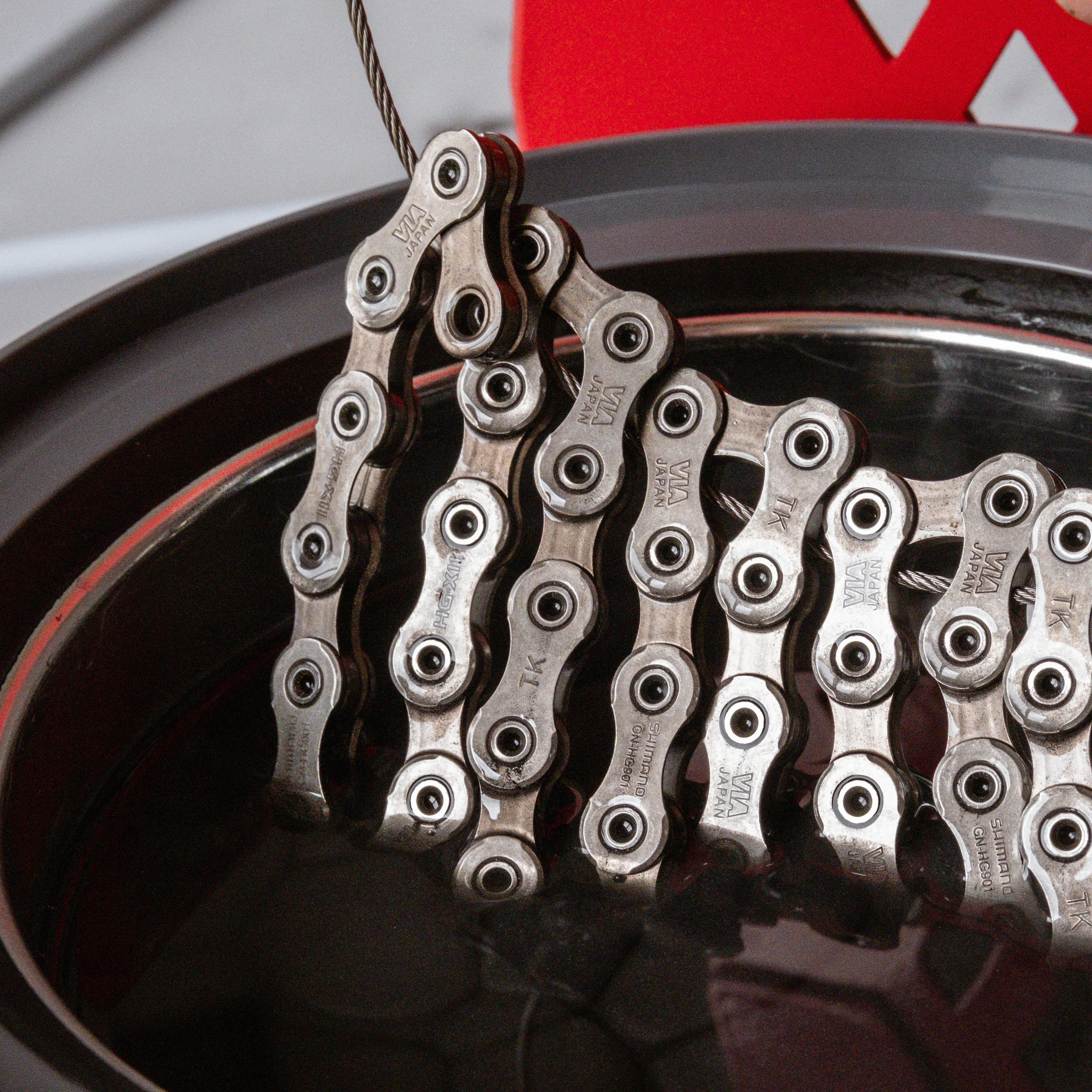 Close-up of Shimano Dura-Ace chain inside SILCA hot melt waxing system with tungsten disulfide coating